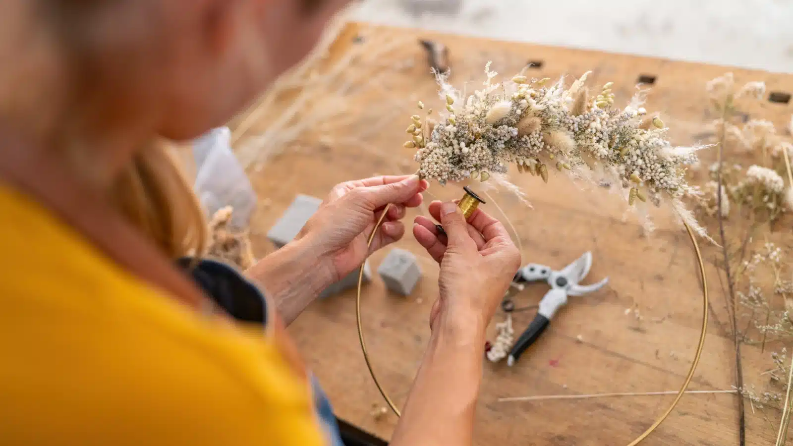 A woman weaves a pretty spring wreath.