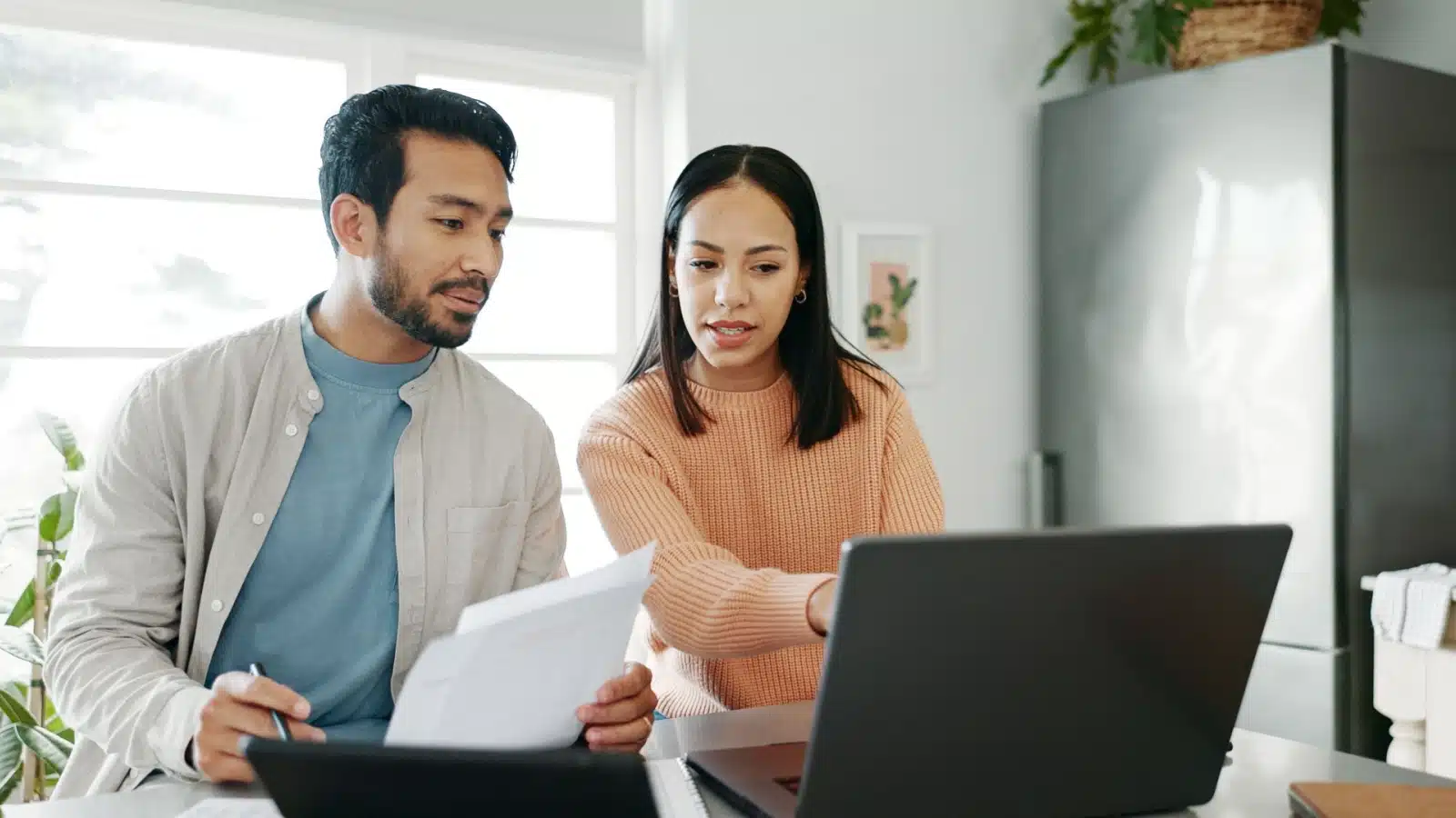 A couple sits together reviewing their finances.