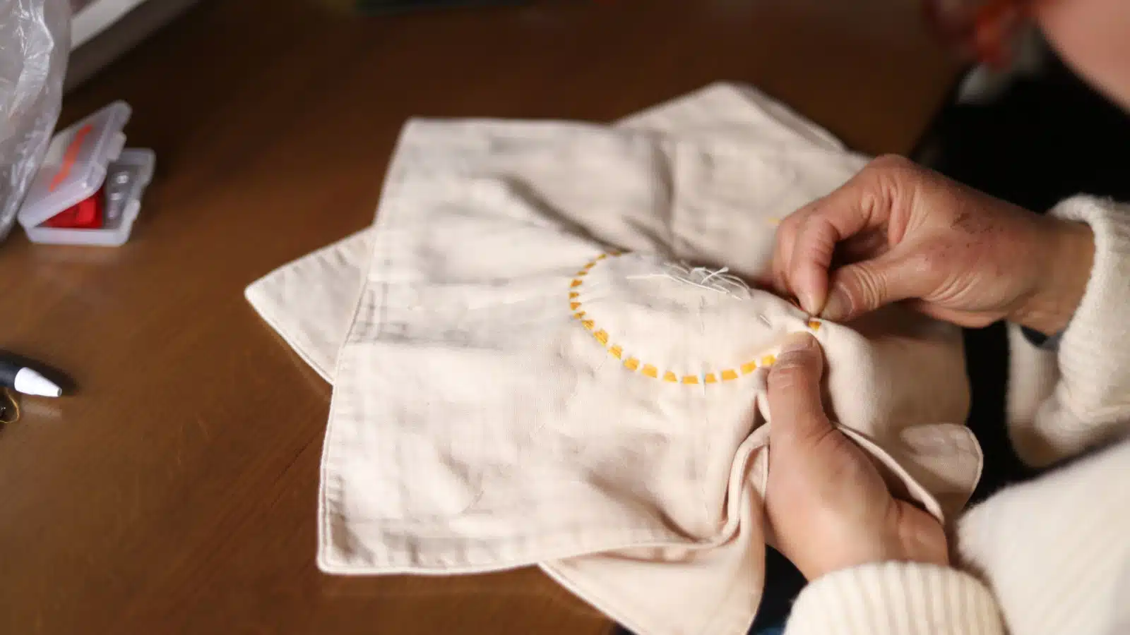 A woman embroidering by hand.