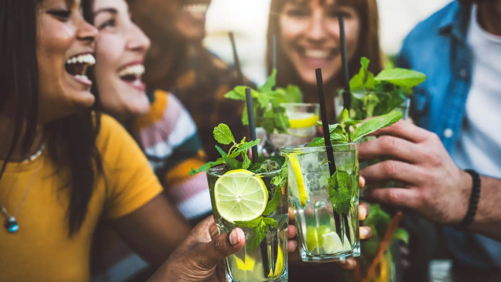 A group of friends enjoy cocktails bursting with spring flavors like lemon and mint.