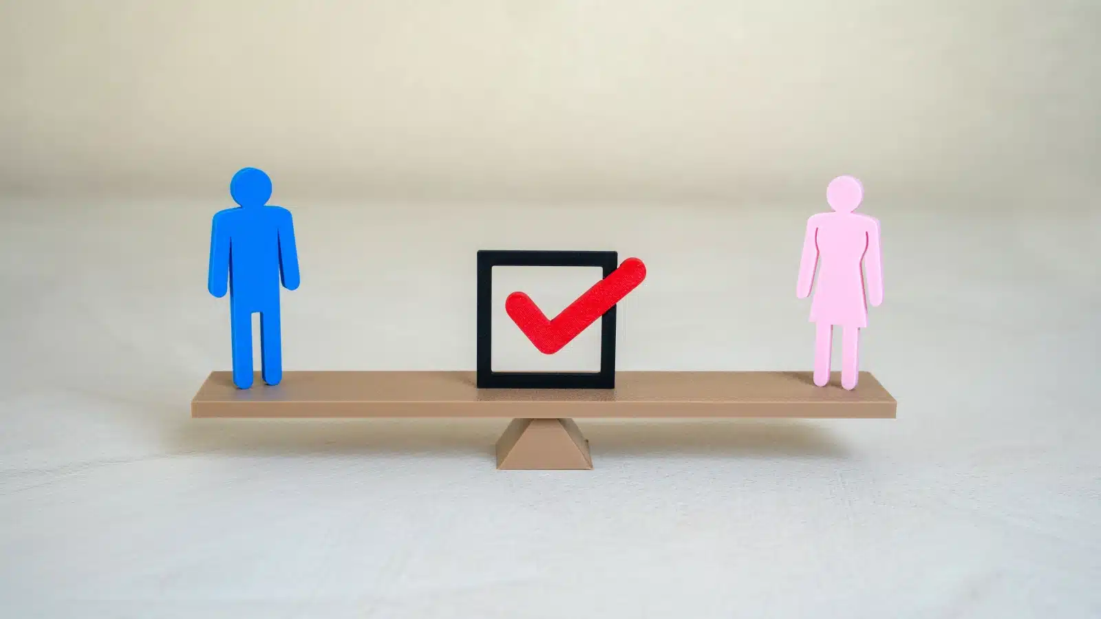 A figure of a man and a woman on a balanced beam to represent gender equality.