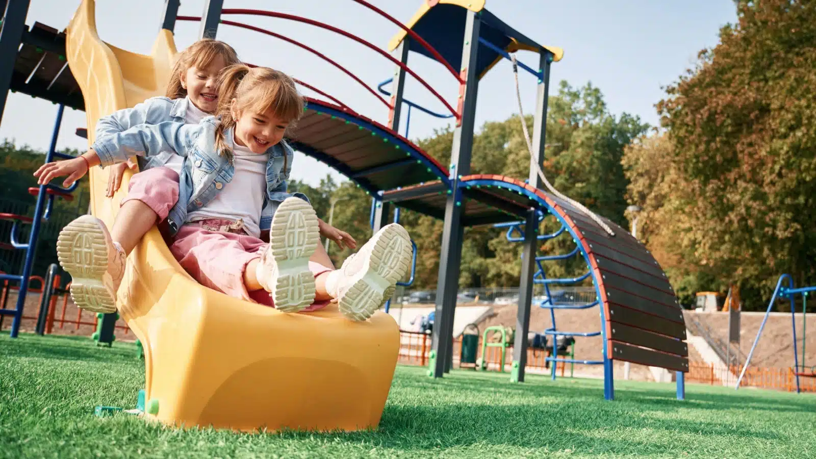 Kids playing on the slide at a playground.