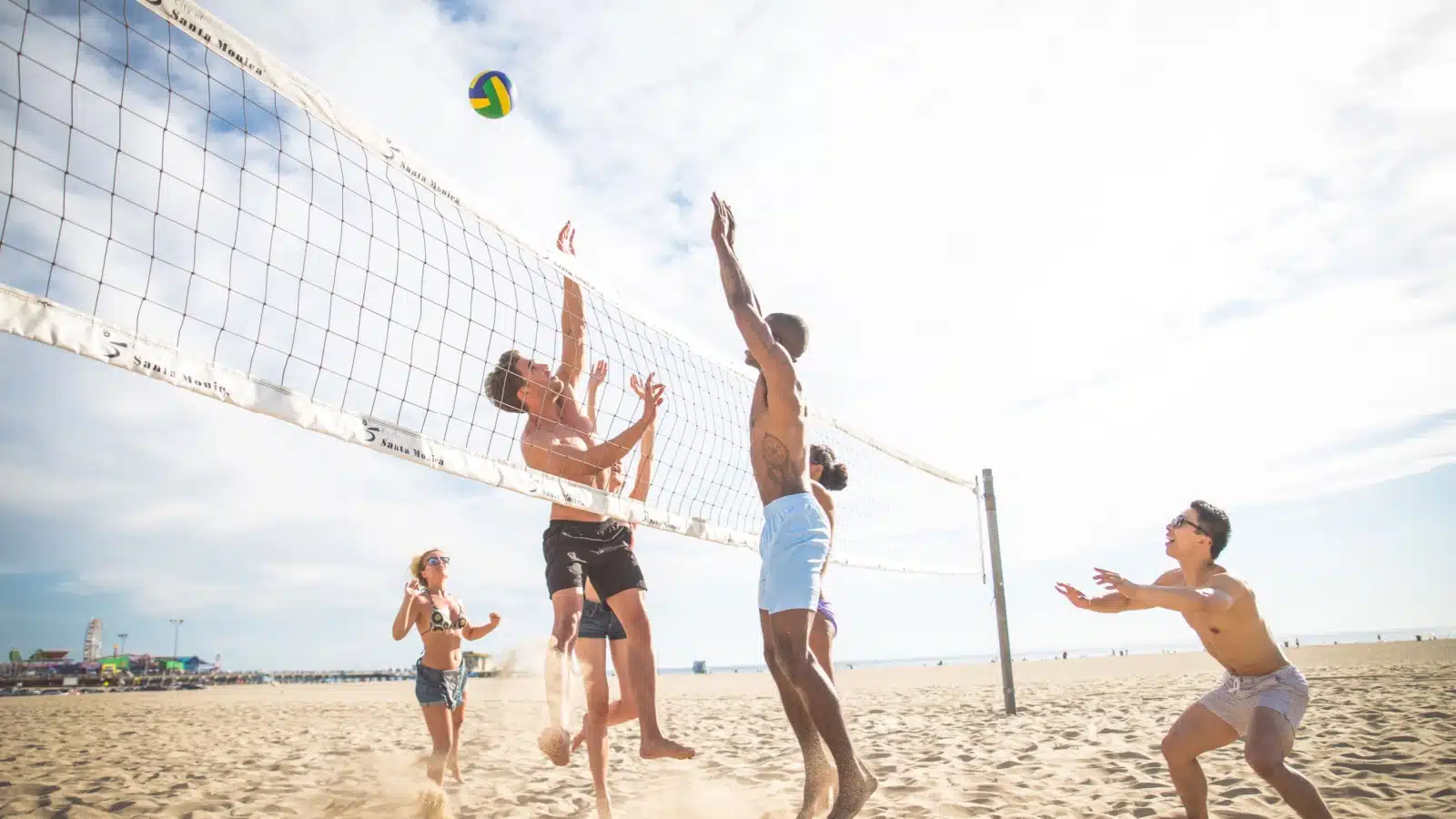A group of friends playing beach volleyball.