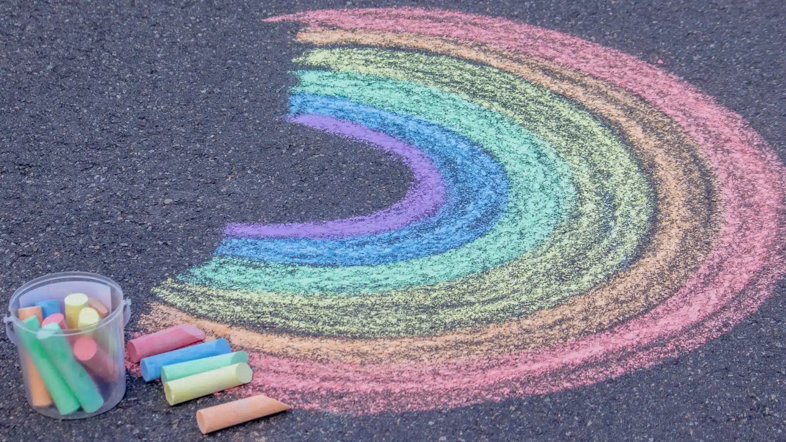 A rainbow drawn with chalk on the sidewalk.