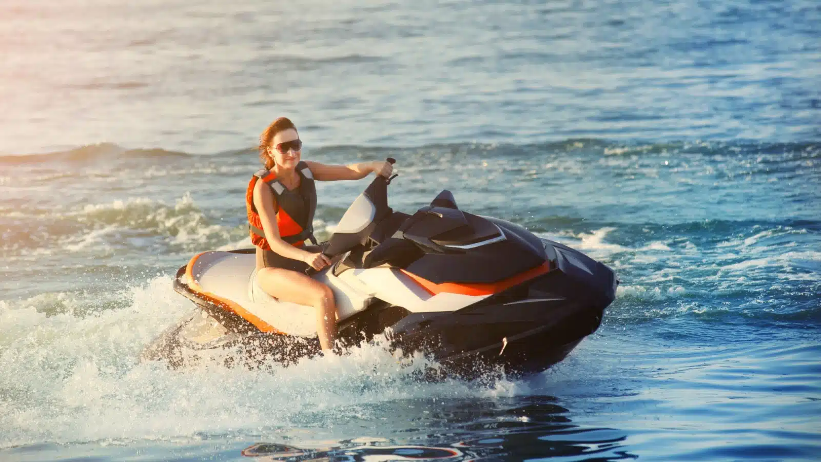 A woman rides a jet ski in the ocean.