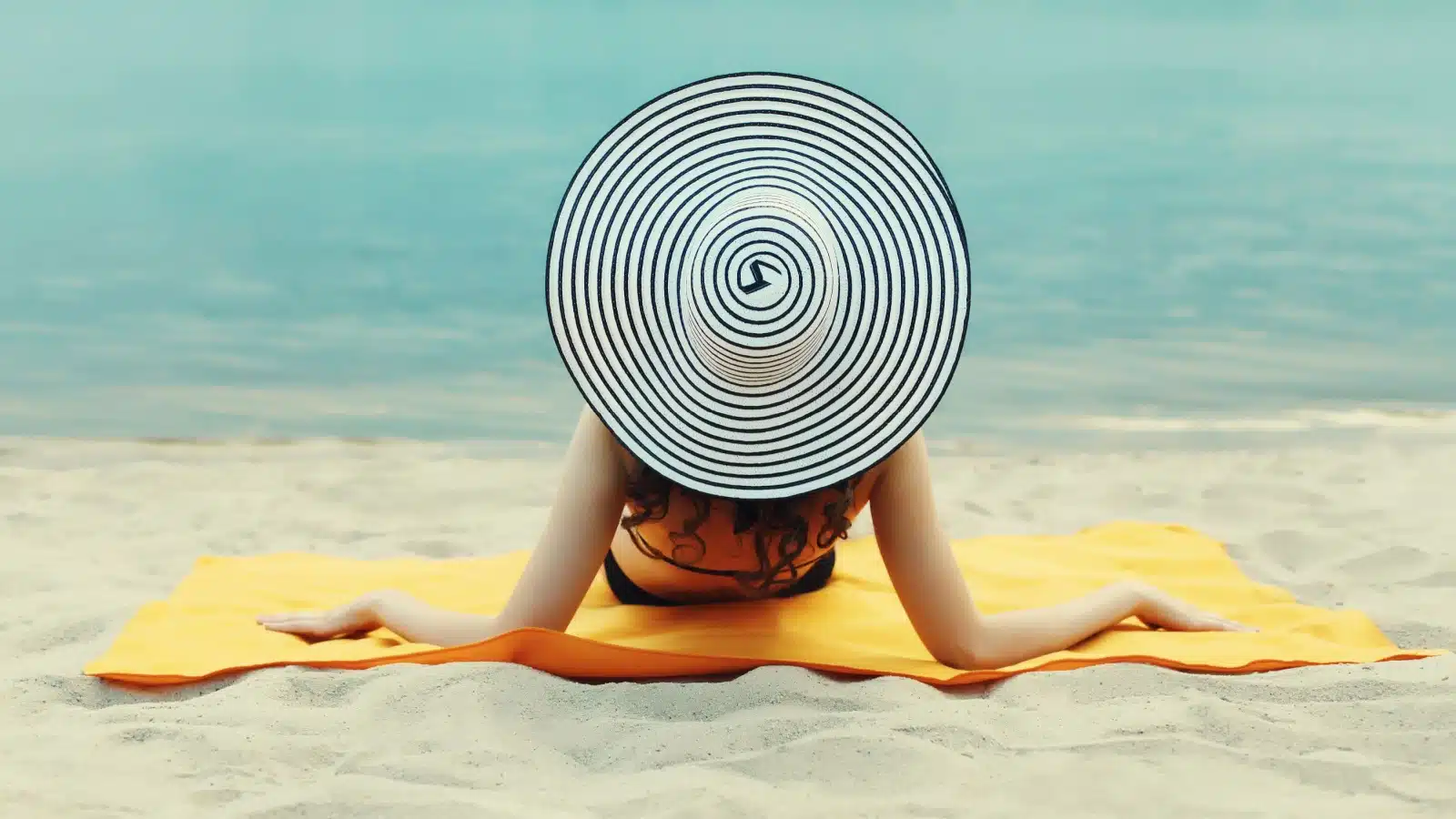 A woman lays out at the beach.