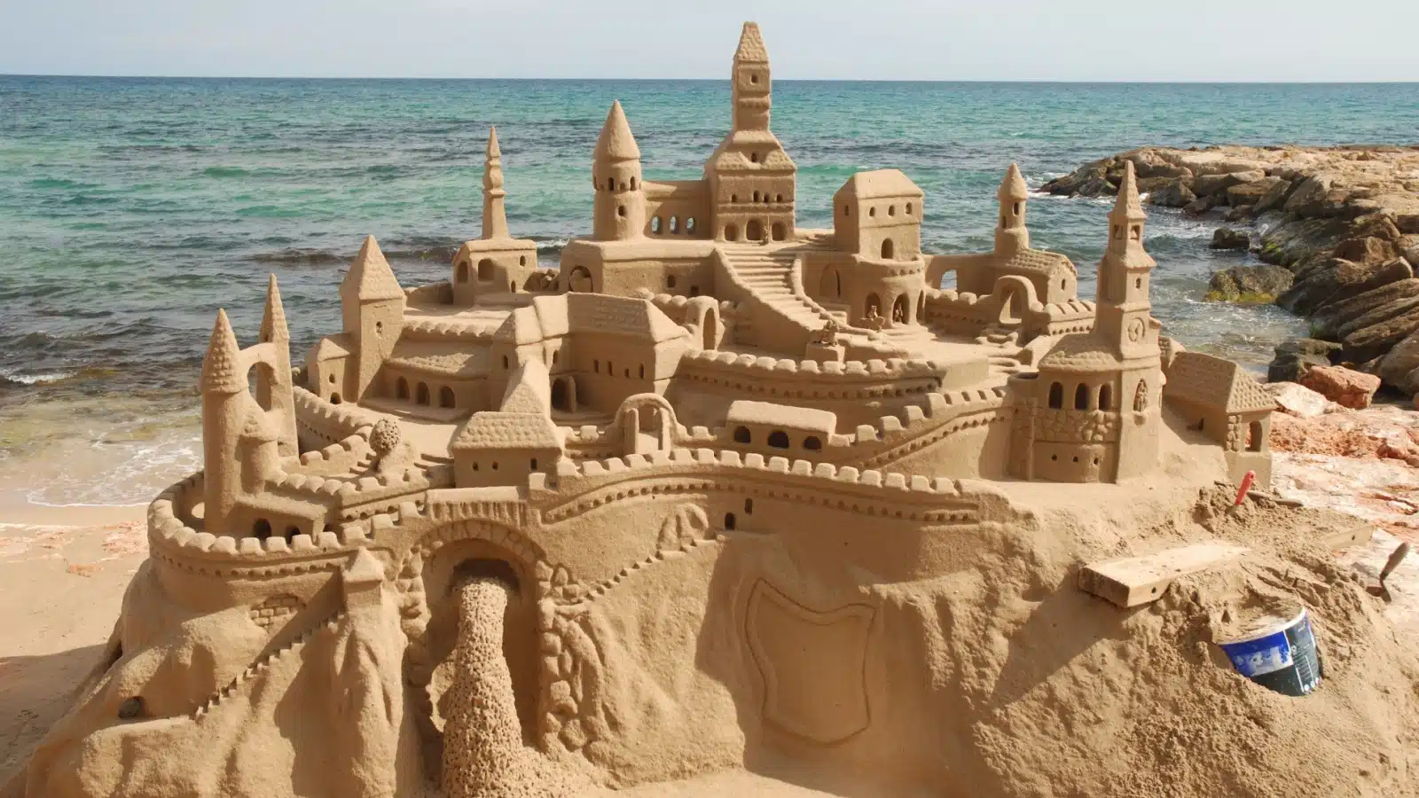 An impressive sand castle on a beach.