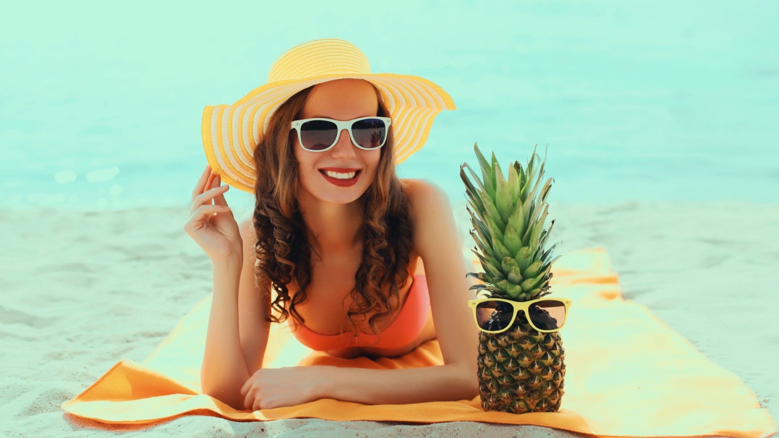 A woman lays on the beach to represent the best summer activities.