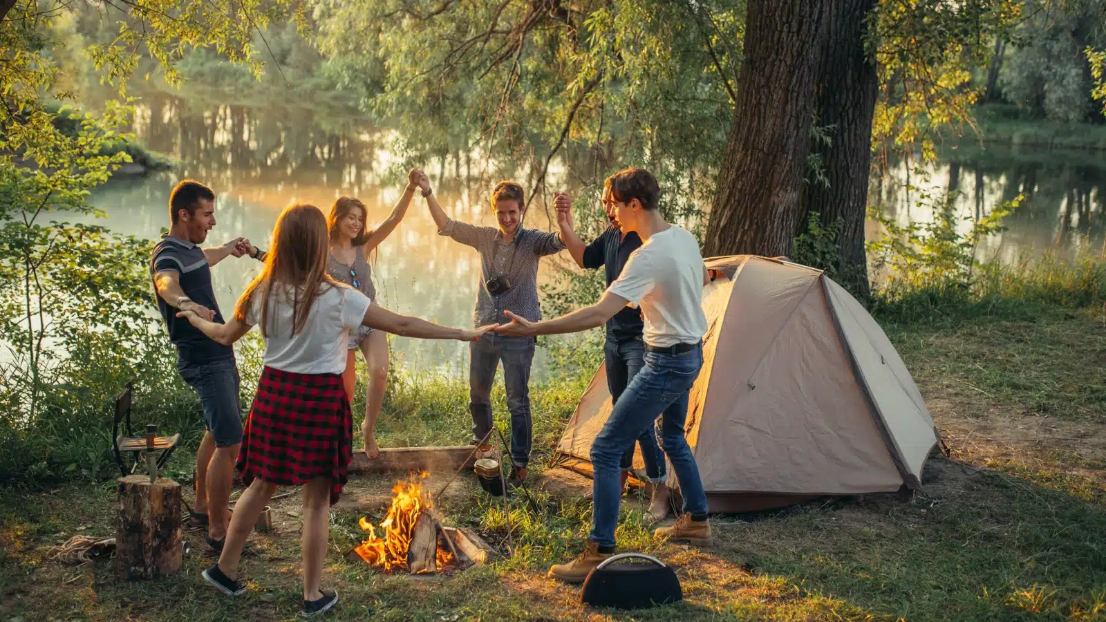 Friends dance around a campfire in a make-shift longest day celebration.