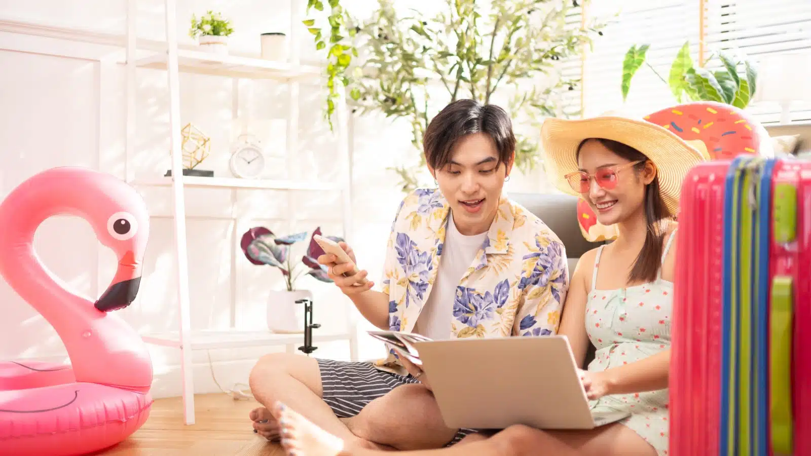 A young happy couple sits in the living room planning their summer activities.
