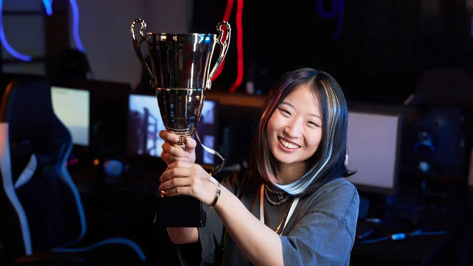 A woman holds up a trophy she won to represent self-efficacy.